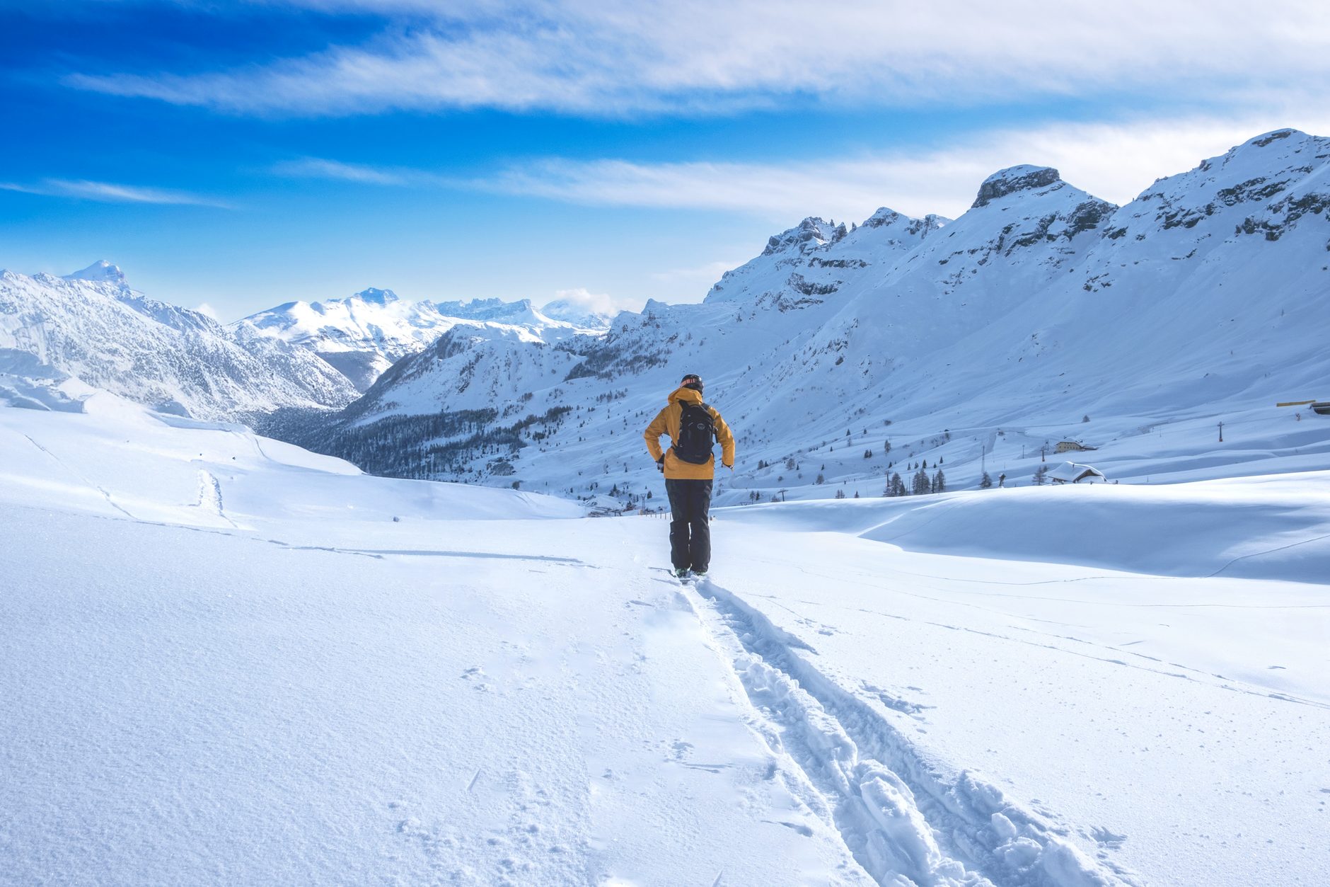 Marcheur dans la neige face aux sommets, grand ciel bleu